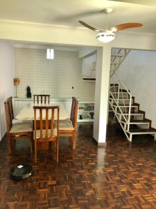 a dining room with a table and chairs and a staircase at Triplex Cor de Chicletes in Curitiba