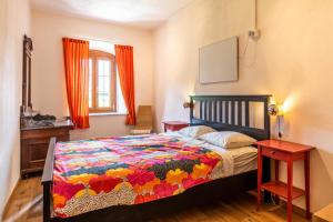 um quarto com uma cama com uma colcha colorida em Il Giardino ai Volti 2P, Caldonazzo Ospitar em Caldonazzo