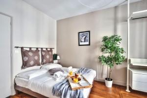 een slaapkamer met een bed met een dienblad met eten erop bij 831 - Near South Arena in Paris Olympic Games 2024 in Parijs