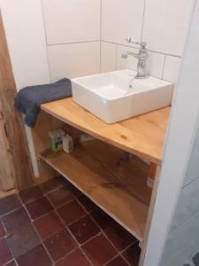 łazienka z białą umywalką na drewnianym stole w obiekcie Chamalières Sur Loire : Un superbe appartement w mieście Chamalières-sur-Loire
