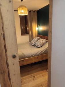 Dormitorio pequeño con cama con marco de madera en Chamalières Sur Loire : Un superbe appartement en Chamalières-sur-Loire