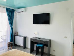 a room with a desk and a tv on a wall at DXN Luxury Apartment 5 in Năvodari