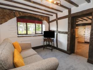 a living room with a couch and a tv at The Coach House in Holywell