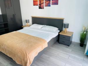 a bedroom with a large bed and two night stands at DXN Luxury Apartment 5 in Năvodari