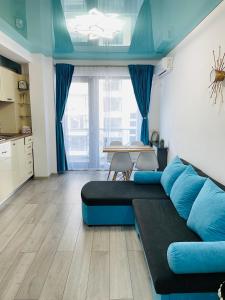 a living room with a blue couch and a table at DXN Luxury Apartment 5 in Năvodari