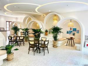 un restaurante con mesas y sillas en una habitación en Lotus Home Cafe - Free Hon Thom Island Waterpark Cable Car, en Phu Quoc