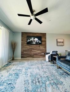 a living room with a ceiling fan and a tv at Luxury Champions Gate Condo-Disney Firework Views! in Kissimmee
