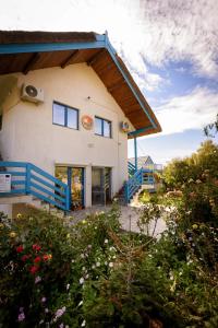 a house with a blue fence and flowers at Splendoarea Deltei in Maliuc +19 photos