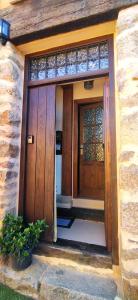 una entrada a una casa con puertas de madera en Casa Ensueño-Los Sitios de Aravalle, en Gilgarcía