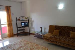 a living room with a couch and a tv at Paradisia Holidays Mauritius in Trou dʼ Eau Douce