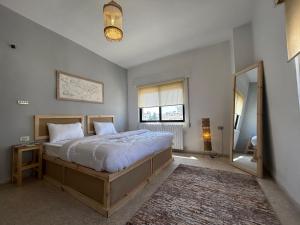 - une chambre avec un grand lit et un miroir dans l'établissement Crafthouse, à Amman