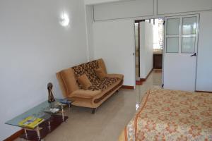 ein Wohnzimmer mit einem Sofa und einem Stuhl in der Unterkunft Paradisia Holidays Mauritius in Trou dʼ Eau Douce
