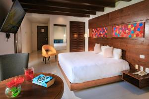 Un dormitorio con una gran cama blanca y una mesa en Soul Beach Boutique Hotel & Spa, en Playa del Carmen