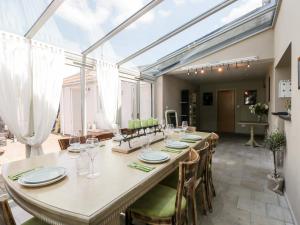 a large dining room with a long table and chairs at Yarn Cottage in Broadway