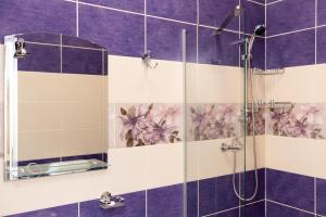 a bathroom with a shower with purple and white tiles at MARCONI GUESTHOUSE in Hunedoara +100 photos