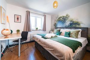 een slaapkamer met een bed, een bureau en een bureau bij Luxury Detached House with Free Parking, Fast Wifi and Smart TV with Netflix by Yoko Property in Coventry