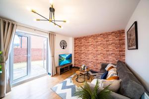 a living room with a couch and a brick wall at Luxury Detached House with Free Parking, Fast Wifi and Smart TV with Netflix by Yoko Property in Coventry +10 photos