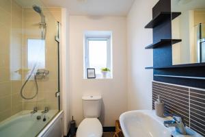 a bathroom with a tub and a toilet and a sink at Luxury Detached House with Free Parking, Fast Wifi and Smart TV with Netflix by Yoko Property in Coventry