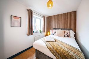 a bedroom with a bed and a window at Luxury Detached House with Free Parking, Fast Wifi and Smart TV with Netflix by Yoko Property in Coventry