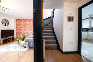 een trap in een huis met een bakstenen muur bij Luxury Detached House with Free Parking, Fast Wifi and Smart TV with Netflix by Yoko Property in Coventry