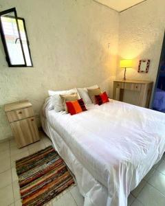 a bedroom with a large white bed with red pillows at Duplex con terraza y estacionamiento p auto! in Mendoza