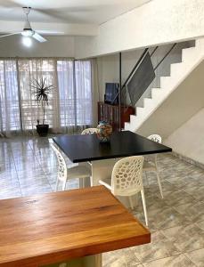 a dining room with a table and chairs and a staircase at Duplex con terraza y estacionamiento p auto! in Mendoza