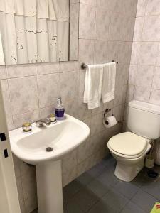 a bathroom with a white sink and a toilet at Duplex con terraza y estacionamiento p auto! in Mendoza