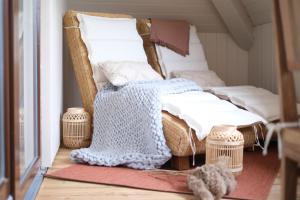 a room with two wicker chairs and a blanket at See ums Eck Moderne Fewo am Hainer See in Neukieritzsch