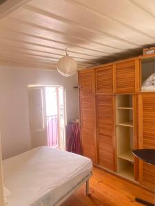 リスボンにあるCasa do Casteloのベッドルーム(ベッド1台、木製キャビネット付)