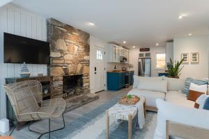 a living room with a white couch and a stone fireplace at Blue Moon Cottage in Lake Lure