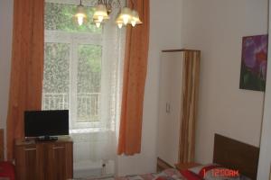 a living room with a window and a television at Pension Easy Journey in Prague