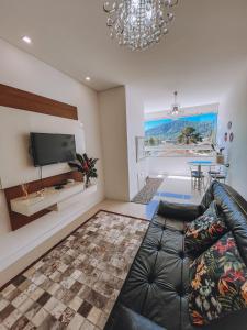 sala de estar con sofá y TV de pantalla plana en Apartamento Penha Beira Mar Beto Carrero World, en Penha
