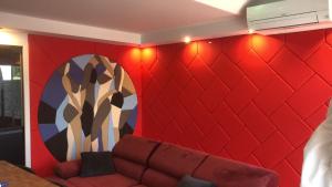 - un mur rouge avec un canapé dans l'établissement Villa-Port Nature-Village Naturiste-1 chambre, au Cap d'Agde