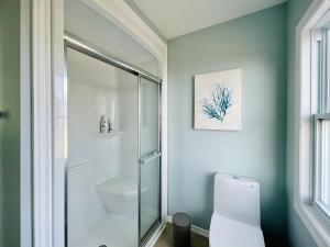 a bathroom with a glass shower and a toilet at Lucky Bay Hideaway - Seaview Sauna & cedar hot tub in Campbellton +42 photos