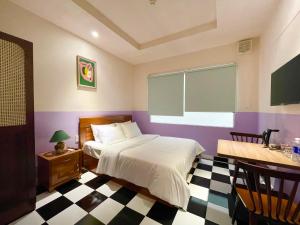 1 dormitorio con 1 cama y suelo a cuadros en Ahu Hotel & Apartment, en Ho Chi Minh