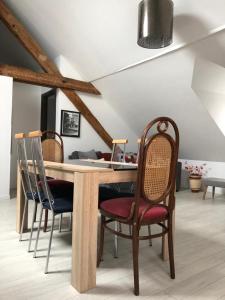 a dining room with a wooden table and chairs at Deluxe Design - City Center Cosy Apartments in Colmar