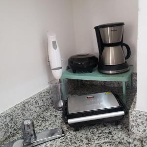 a kitchen counter with a coffee maker and a toaster at Orla da Pampulha Flat Completo in Belo Horizonte