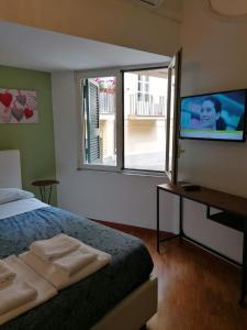 Schlafzimmer mit einem Bett und einem Flachbild-TV in der Unterkunft Residence e Appartamenti Ascensione in Neapel