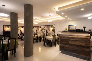 a restaurant with tables and chairs and a bar at Pensiunea Heveder in Praid