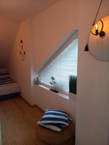 a room with a window with a bed and a stool at Apartament Bałtycki Lux in Rewa