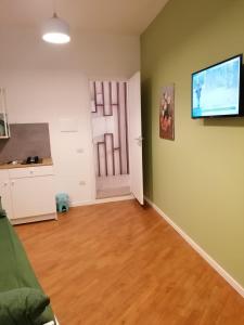 ein Wohnzimmer mit einem Flachbild-TV und einer Tür in der Unterkunft Residence e Appartamenti Ascensione in Neapel