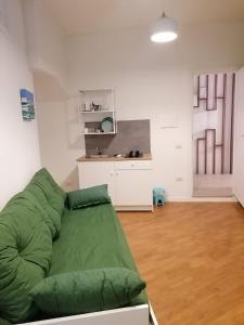 拿坡里的住宿－Residence e Appartamenti Ascensione，一间带绿色沙发的客厅和一间厨房