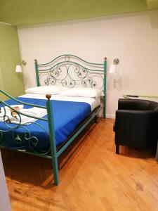 Schlafzimmer mit einem Bett mit blauer Bettwäsche und einem Stuhl in der Unterkunft Residence e Appartamenti Ascensione in Neapel
