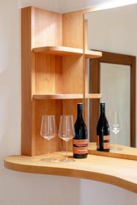 two bottles of wine and two glasses on a shelf at Goldenes Schiff in Passau
