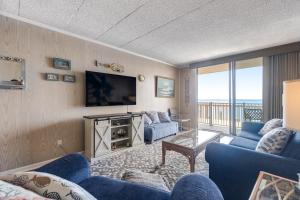 a living room with blue chairs and a flat screen tv at Bayside Beauty in Ocean City