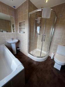 a bathroom with a shower and a toilet and a sink at Queenswood Hotel in Weston-super-Mare