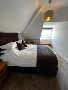 a bedroom with a large bed with white sheets and pillows at Queenswood Hotel in Weston-super-Mare