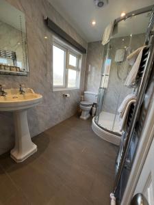 a bathroom with a sink and a shower and a toilet at Queenswood Hotel in Weston-super-Mare