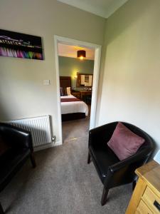 a bedroom with a bed and a chair and a mirror at Queenswood Hotel in Weston-super-Mare