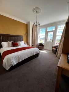 a bedroom with a large bed and a chandelier at Queenswood Hotel in Weston-super-Mare +37 photos